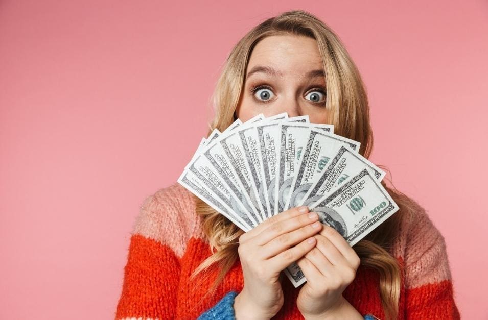 Woman hiding behind money.